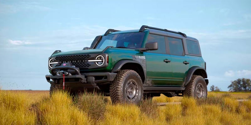A green 2024 Ford Bronco parked in a field.