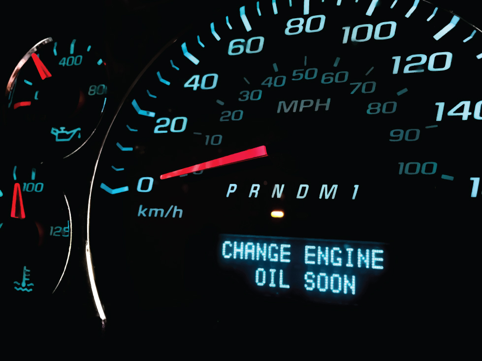 A photo of a car's dashboard with a "change engine oil soon" light illuminated.