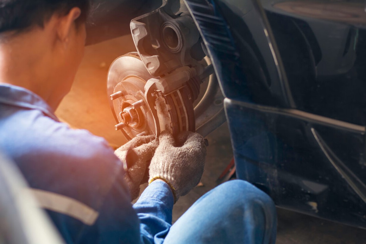 A photo of a mechanic repairing brakes.