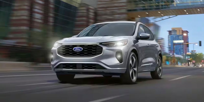 A photo of a gray 2024 Ford Explorer driving down a city street.