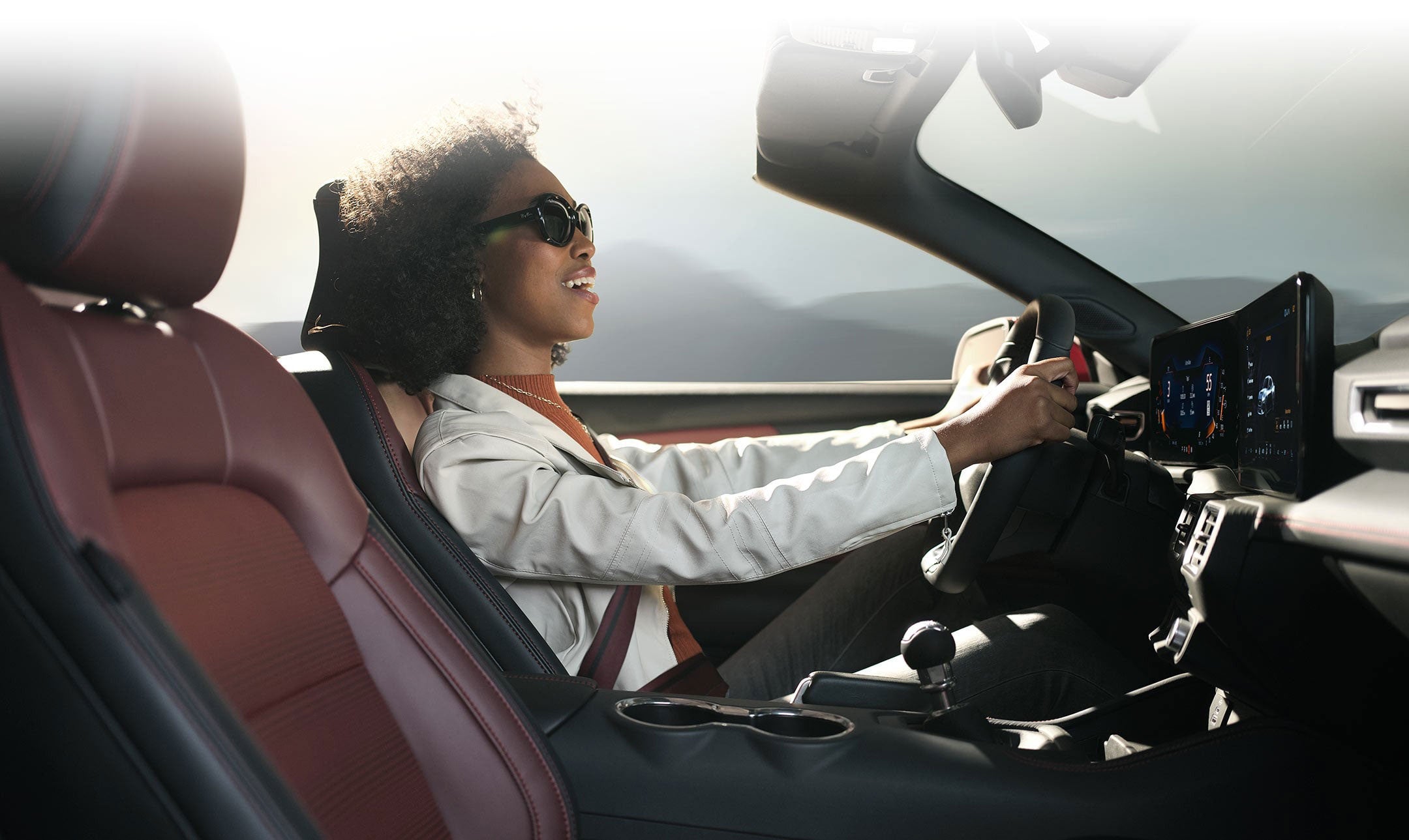 A photo of a woman in the driver's seat of a 2024 Ford Mustang