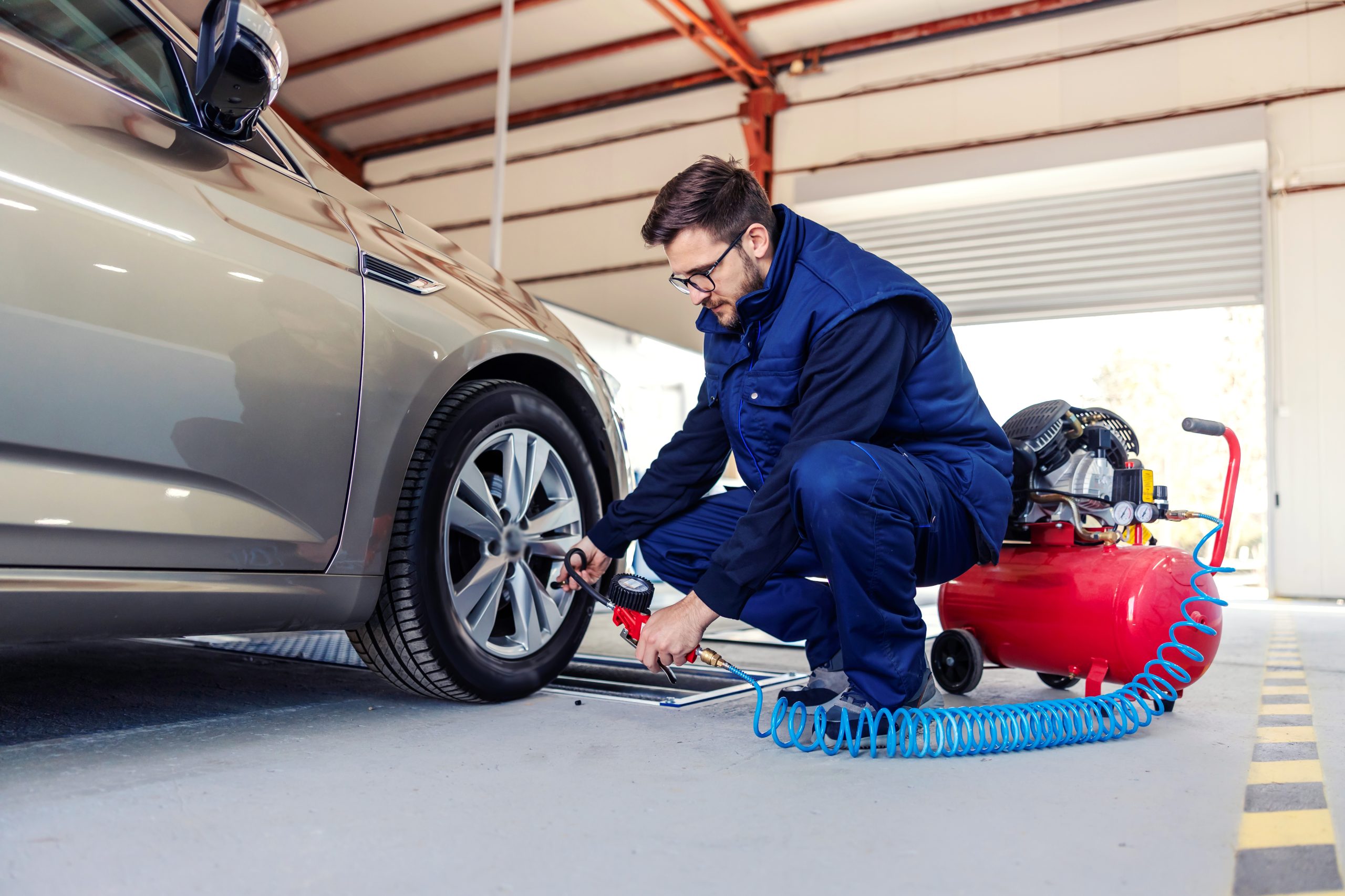 A photo of a mechanic putting air in tires
