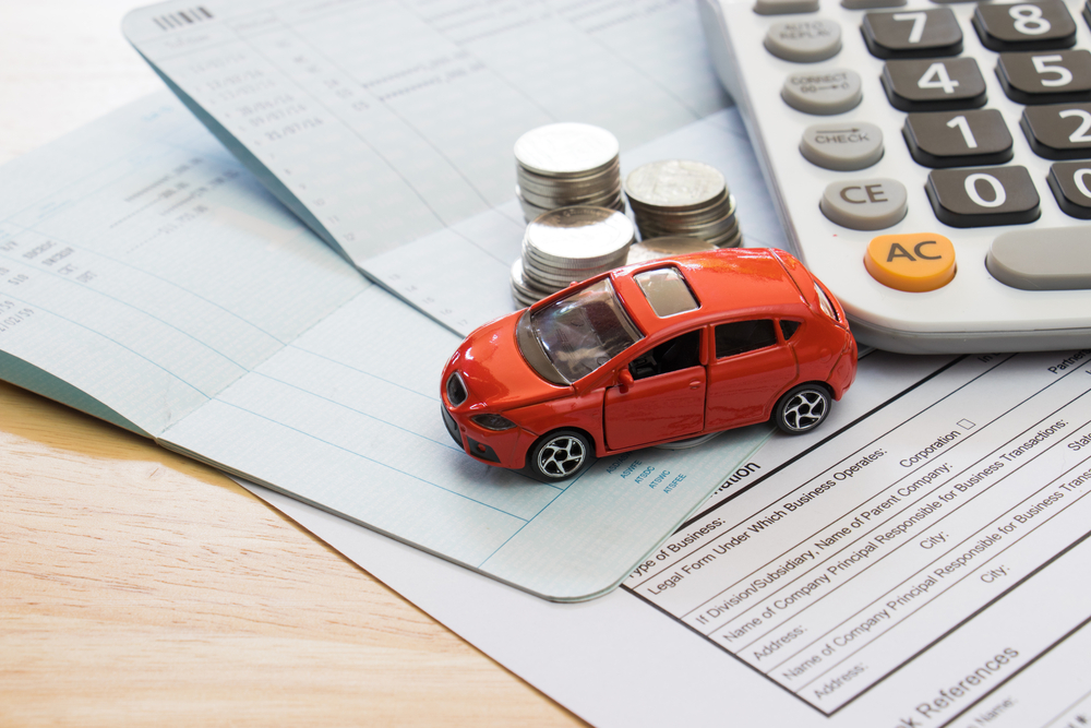 A photo of papers, a toy car, calculator, and coins
